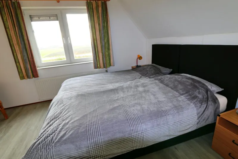 Schlafzimmer im Obergeschoss mit großem Doppelbett